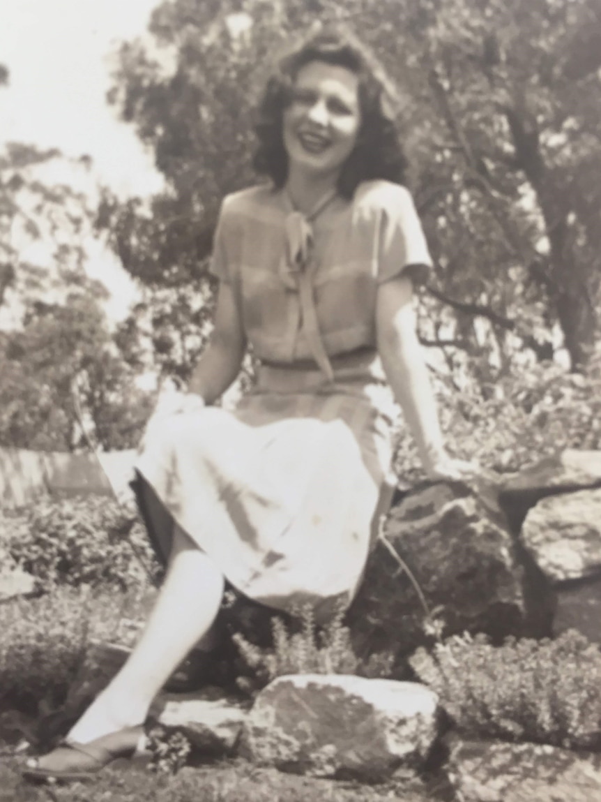 black and white photo of Betty Walsh sitting in a garden. 