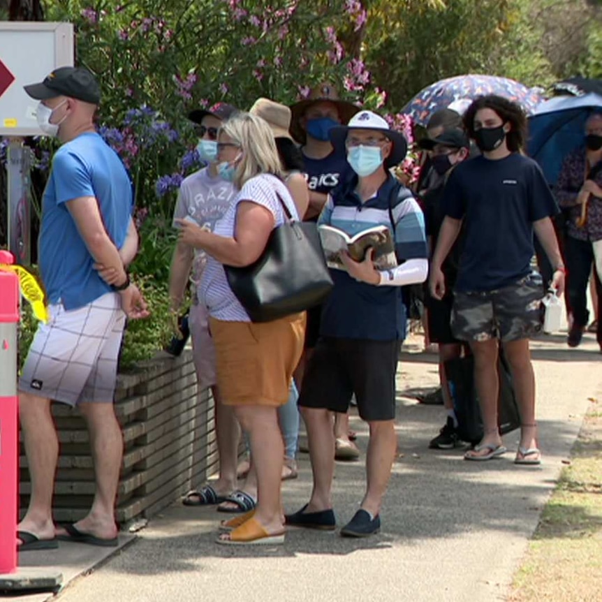 A picture of people lined up in masks at a COVID testing centre in Melbourne.