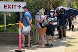 A picture of people lined up in masks at a COVID testing centre in Melbourne.