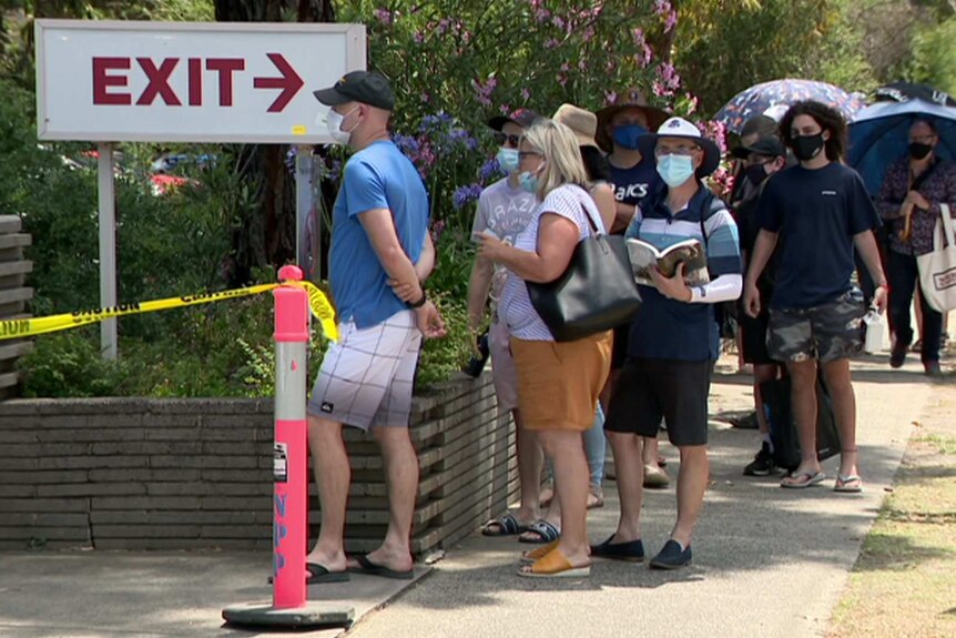 A picture of people lined up in masks at a COVID testing centre in Melbourne.