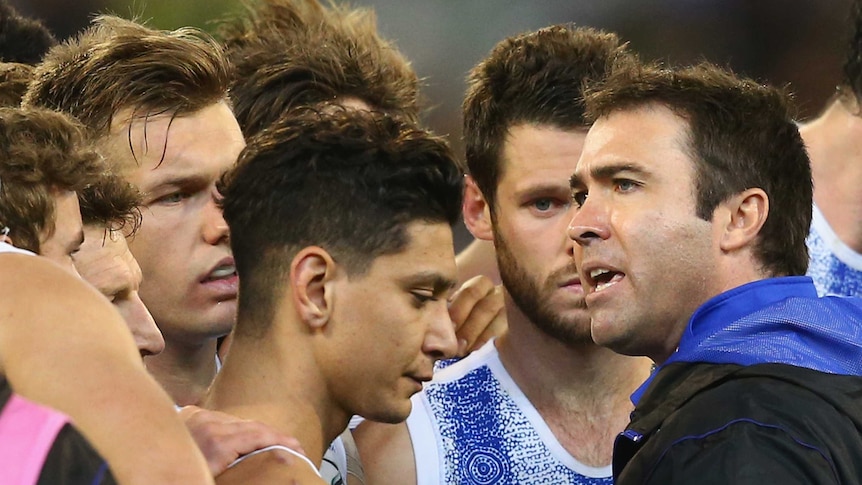 Brad Scott (R) talks to North Melbourne players in round nine, 2015 against Collingwood at the MCG.