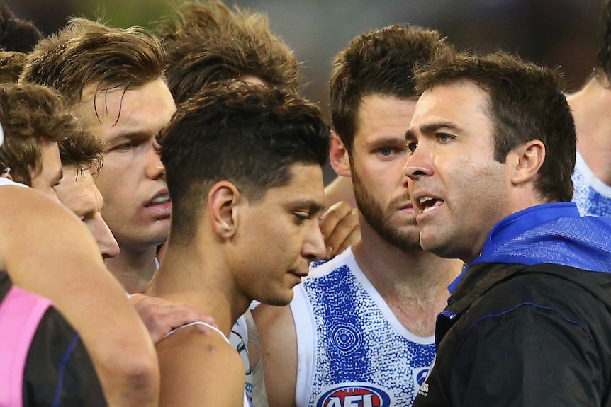 Brad Scott (R) talks to North Melbourne players in round nine, 2015 against Collingwood at the MCG.