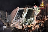 Italian firefighters and rescuers search for survivors among the rubble of a collapsed building.