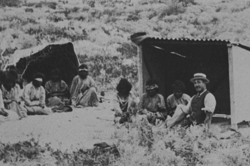 Photo of a group of indigenous patients sitting outside makeshift huts on the lock hospital islands, off the WA coast
