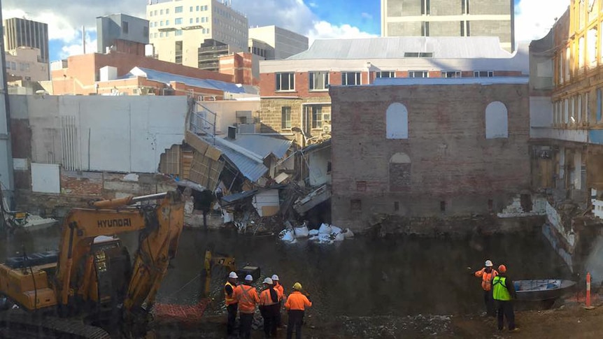 Workers stand in front of the flooded Myer redevelopment site in Hobart, July 2016.