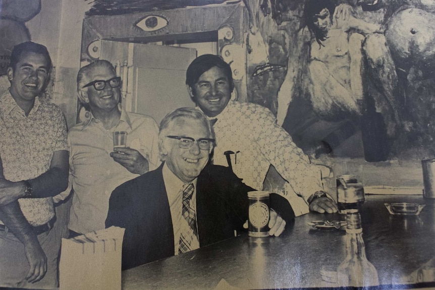 Black and white photograph of four men drinking at a pub