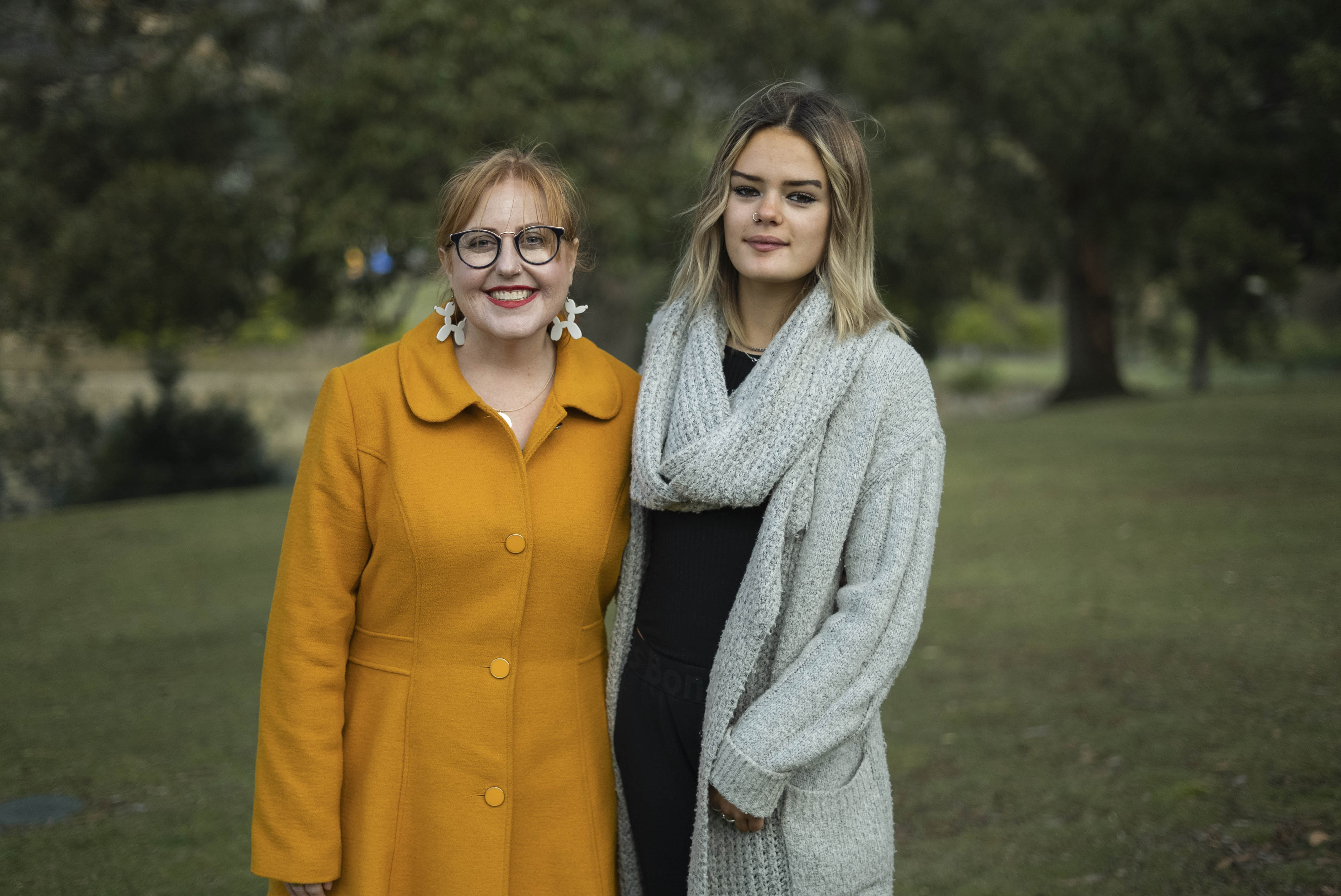 Two women standing in a park.