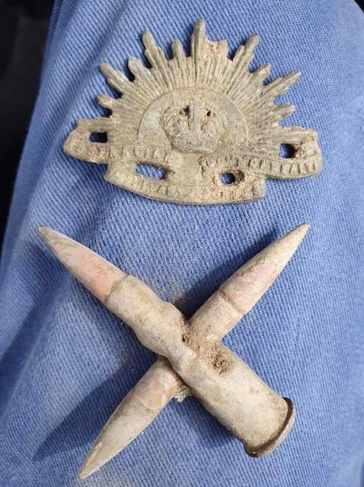 A very old war badge and a cross made out of spent ammunition.