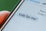 A phone containing a message saying 'vote for me'.