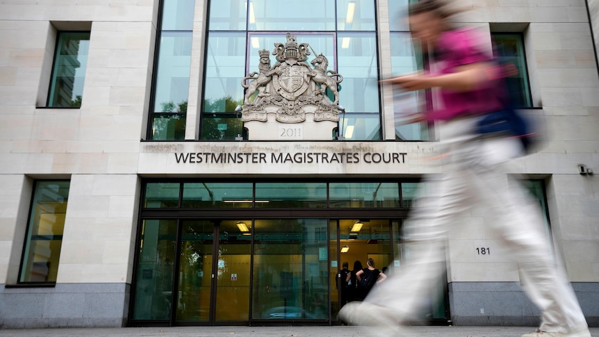 Woman walks past entrance to London's Westminster Magistrates Court.