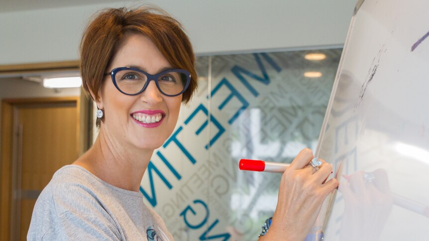 Dr Sue Pillans draws on a white board in Brisbane.