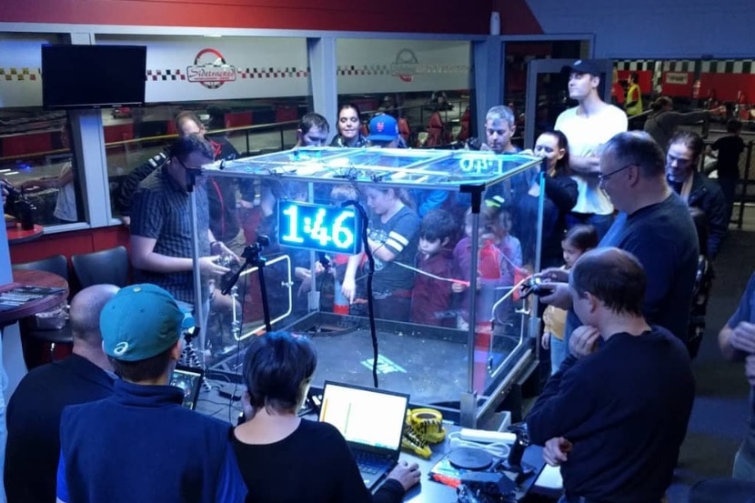 People gather around a plastic encased combat box.