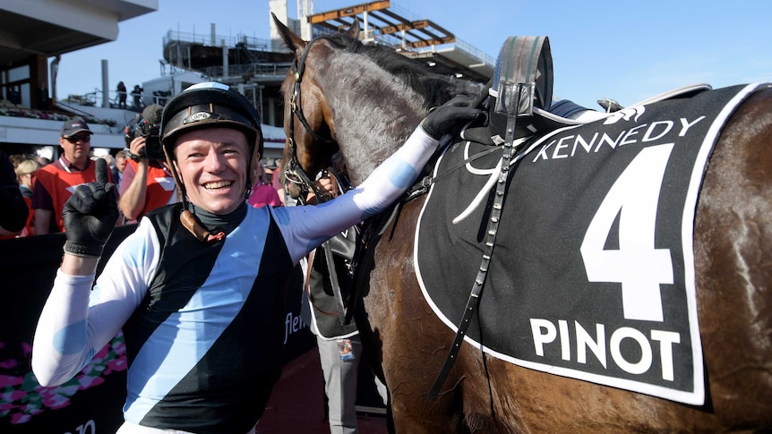 Stephen Baster celebrates his win on Pinot in the 2017 Oaks at Flemington.