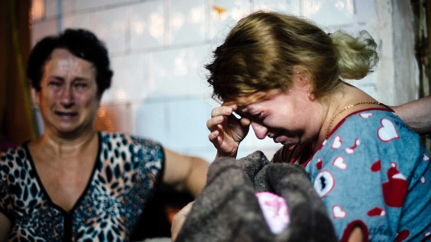 Woman cries in makeshift bomb shelter in Ukraine