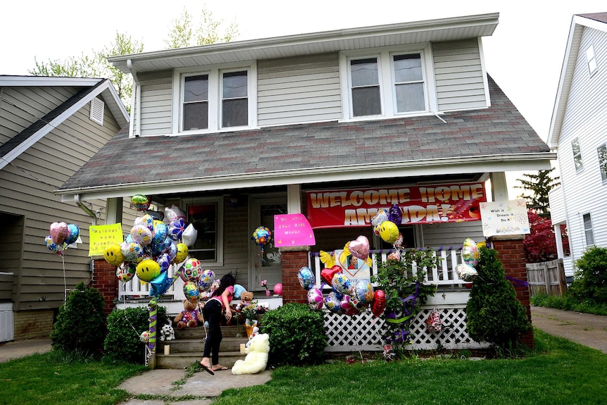 House covered with flowers and balloons from well-wishers.