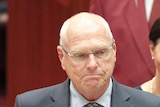 Jim Molan holds a bible while being sworn into the Senate 