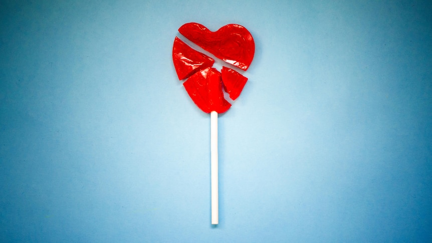 birds eye view of smashed heart shaped lollipop against blue background