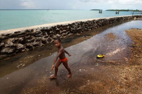 A child plays behind the leaky seawall on Saibai in February 2012, the largest island in the Torres Strait.