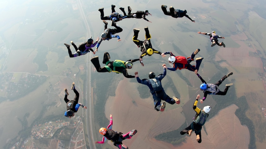 A group of skydivers holding hands in freefall