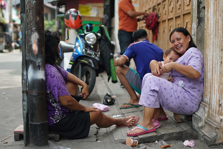 Women sit in Tambora slum