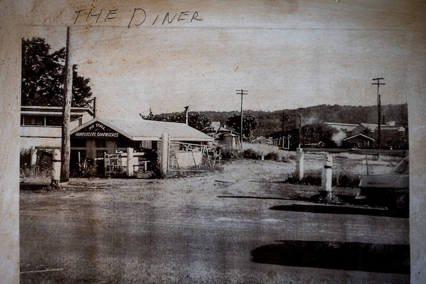 Old black and white photo stuck to wall with 'the diner' written in pencil above.