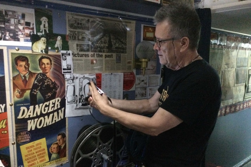 David McGowan, Laurieton Plaza Theatre owner, looking at his collection of old slides and films.