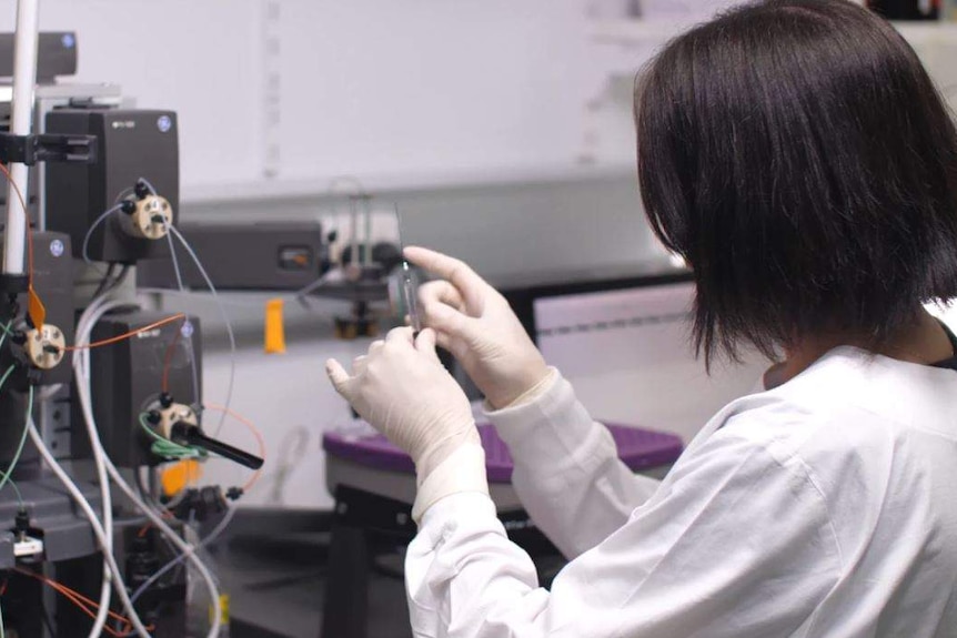 Scientist holding syringe.