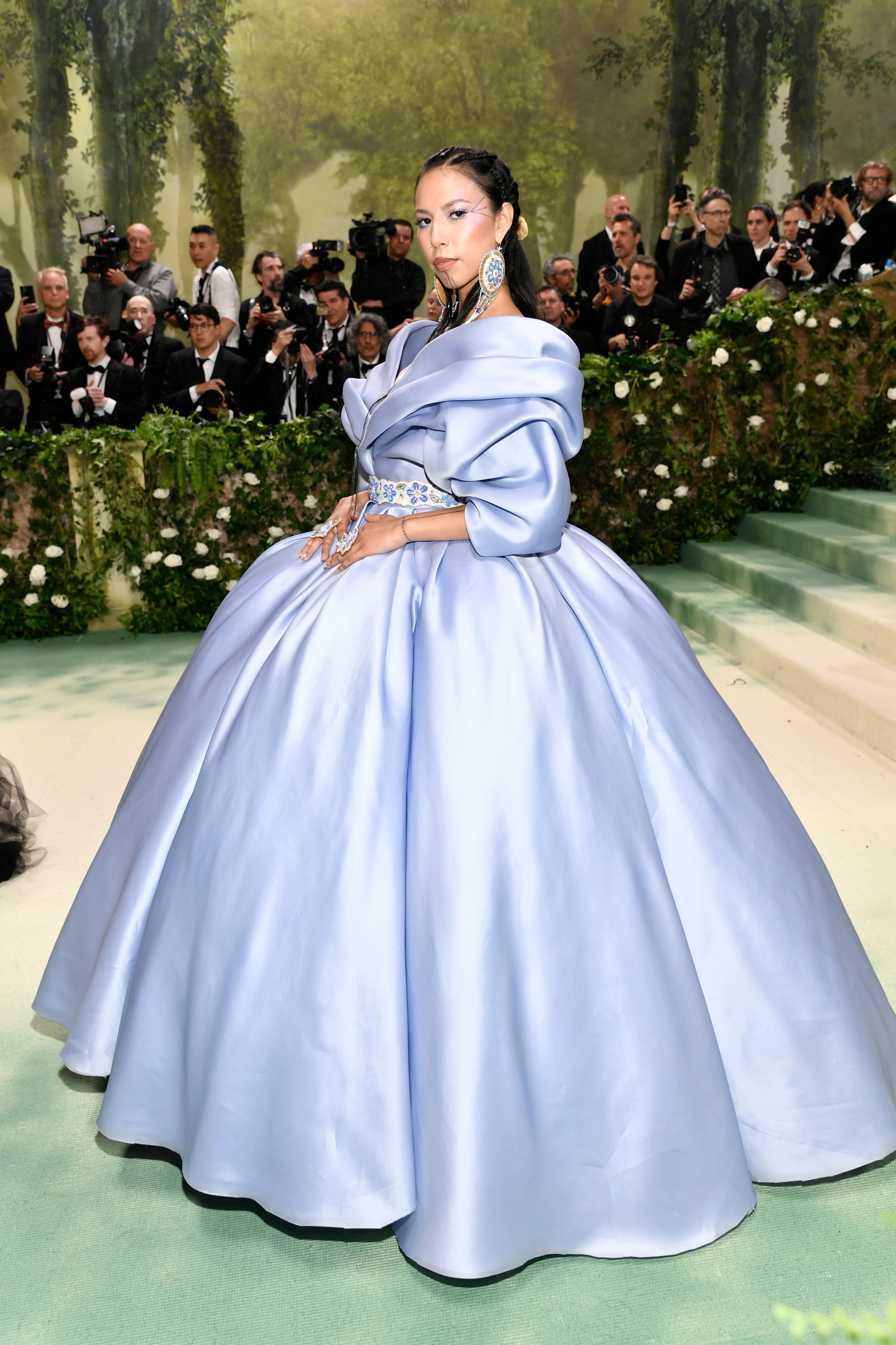 Quannah Chasinghorse wearing a big silky gown with puffy sleeves and a full skirt