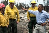 US president Barack Obama speaks with fire fighters while touring the Mountain Shadow neighbourhood.