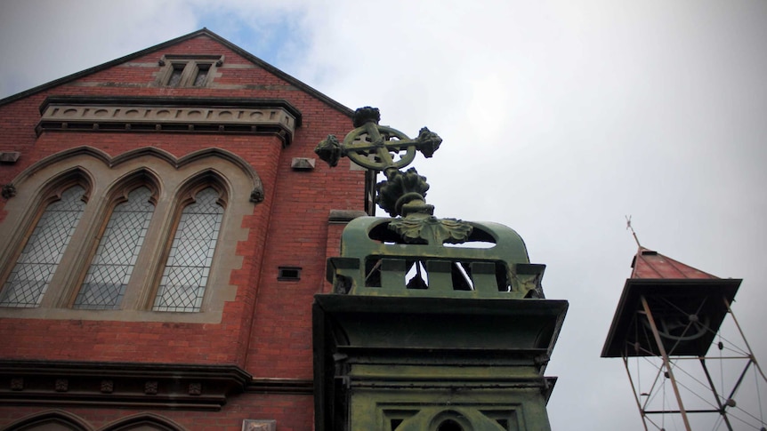 Looking up at exterior of Ballarat Catholic church and cross