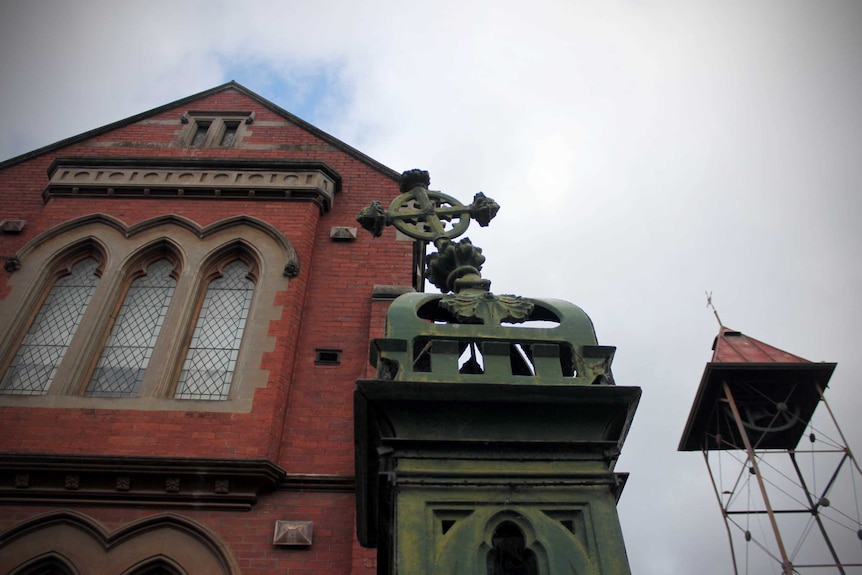 Looking up at exterior of Ballarat Catholic church and cross