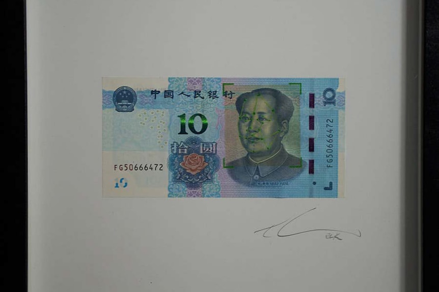 A photo of an artwork showing 10 Yuan with green lights on the Chinese leader's face.