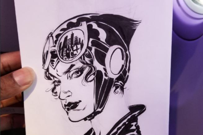 A picture of the drawing of Catwoman on an sick bag in black pen.