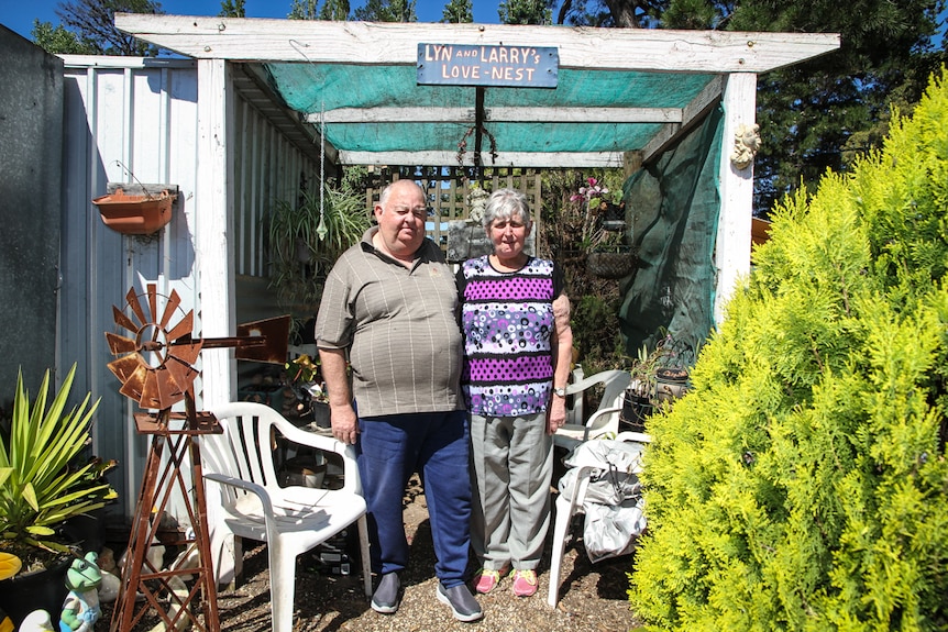 Larry and Lyn Fox standing beneath an awning with the sign - Lyn and Larry's Love Nest.