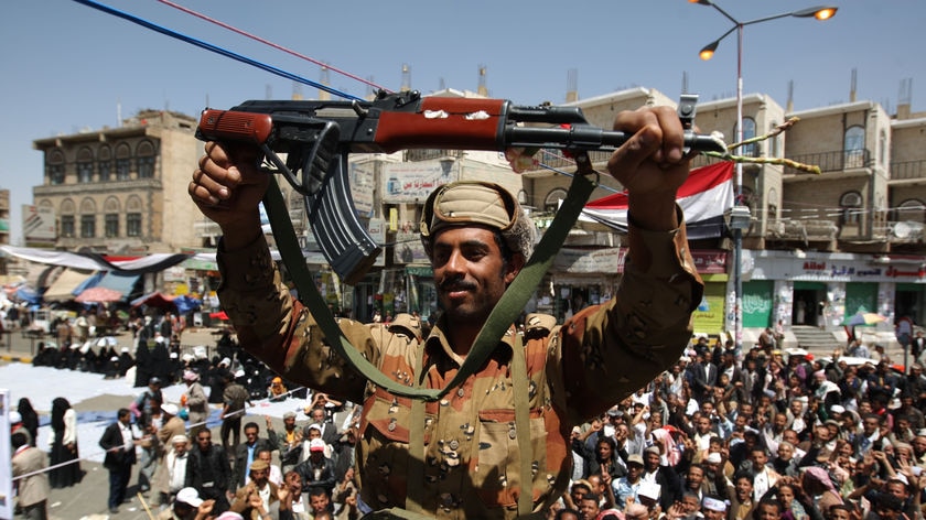 A defected Yemeni soldier holds up his weapon as he joins anti-government protestors March 21, 2011 (AFP)