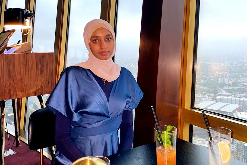 A woman wearing the hijab sitting in a restaurant.