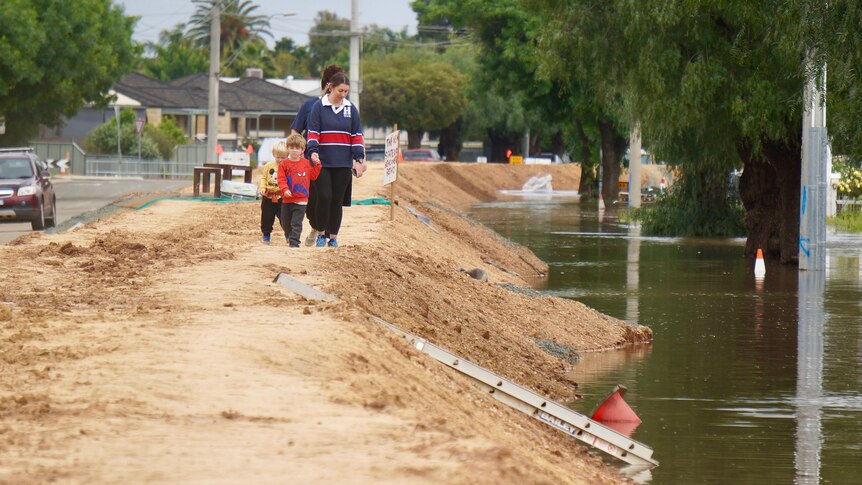 A family walks along the Echuca flood levee
