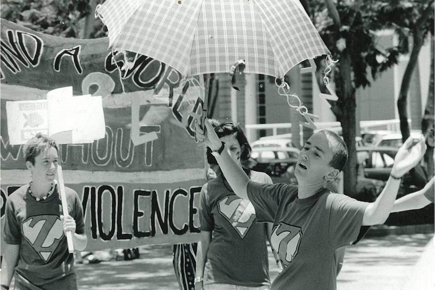 A woman dances with an umbrella in a Reclaim the Night march.