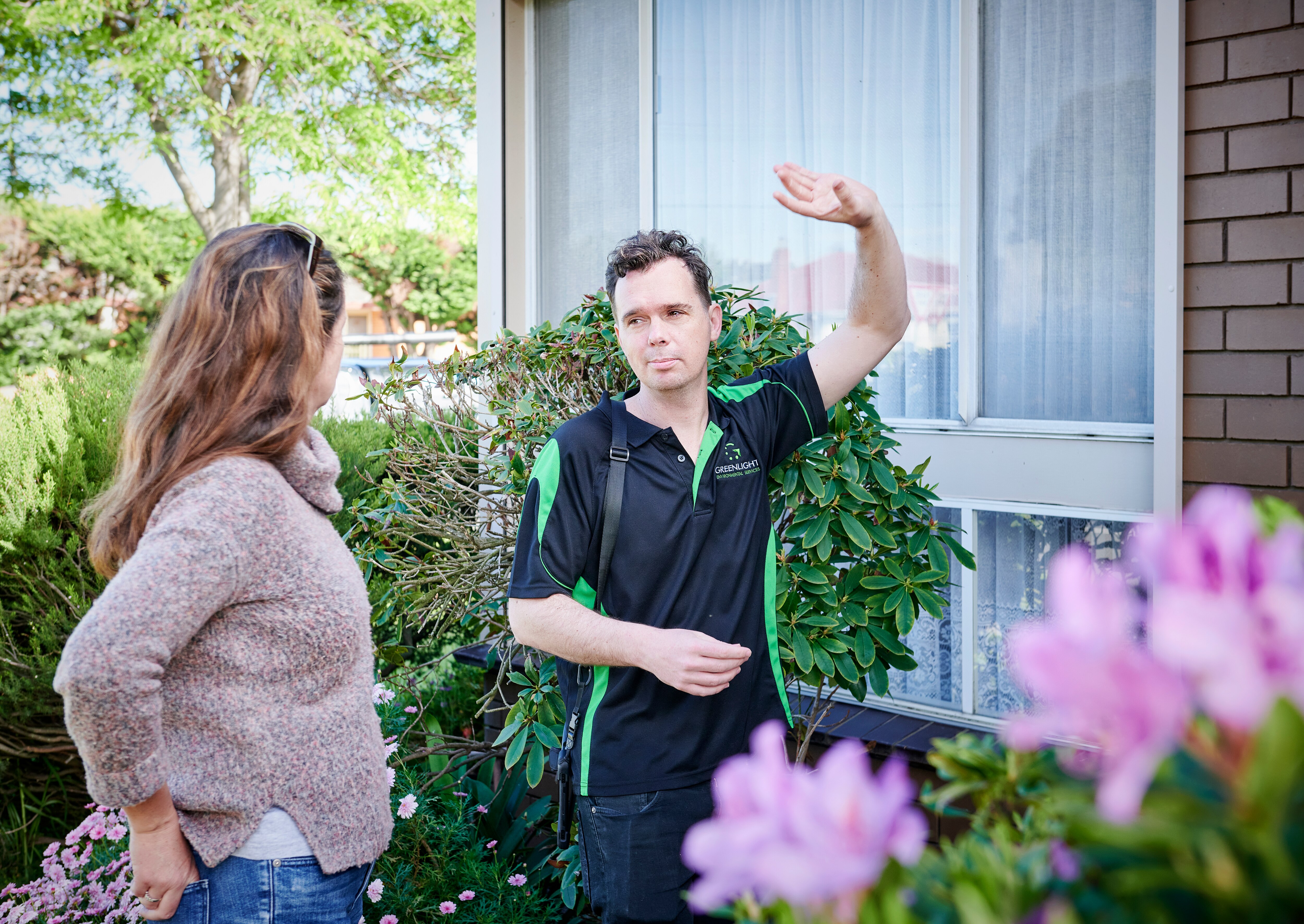 Asbestos expert Michael Tierney speaking with a client outside her home.
