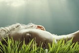 Closeup of woman's head sleeping in lush grass