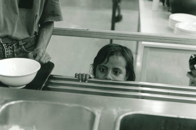 An East Timorese girl looks over the food counter at Puckapunyal meal hall, in 1999.