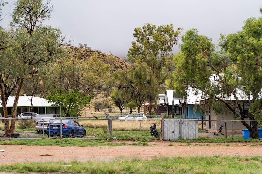 A winding road in the community, surrounded by houses and power poles.