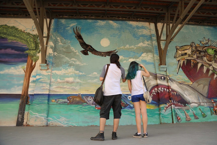 Couple checks out Rio mural