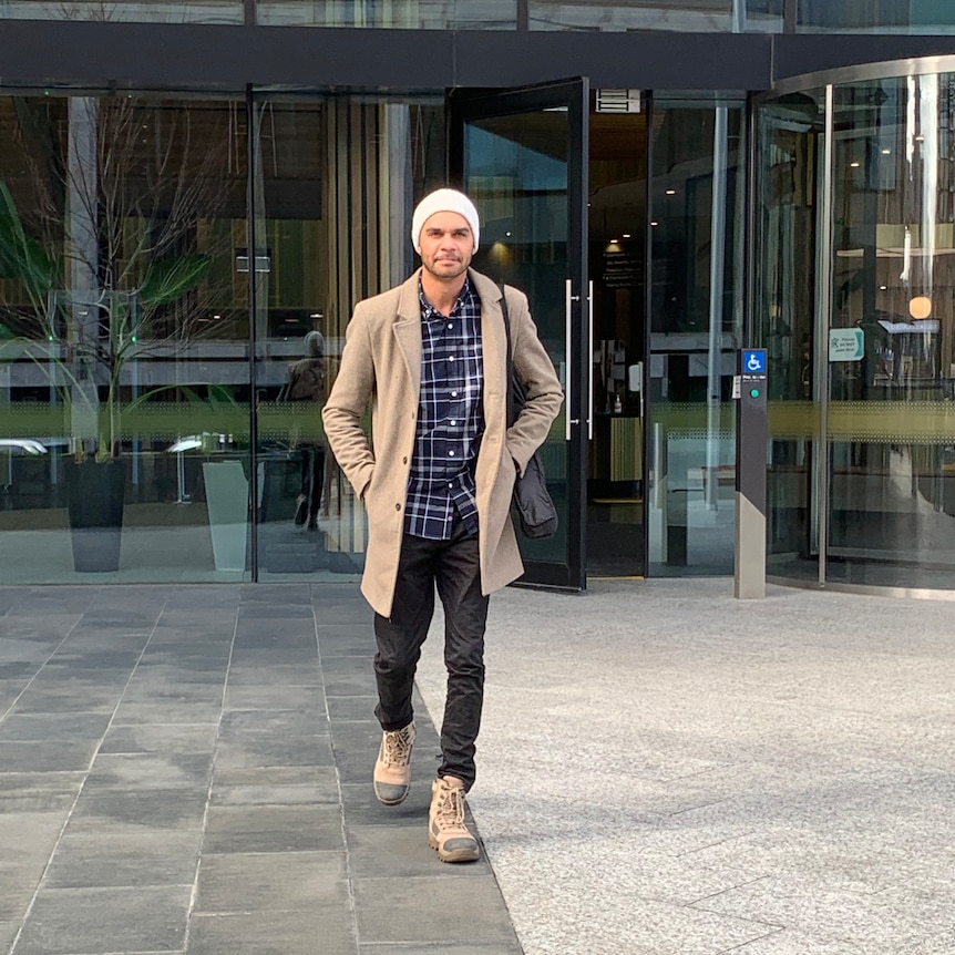 A man walks out of the doors of the ACT law courts.