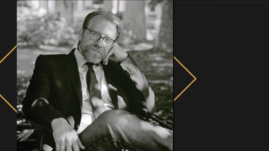 Author image, George Saunders stitting on chair outside.