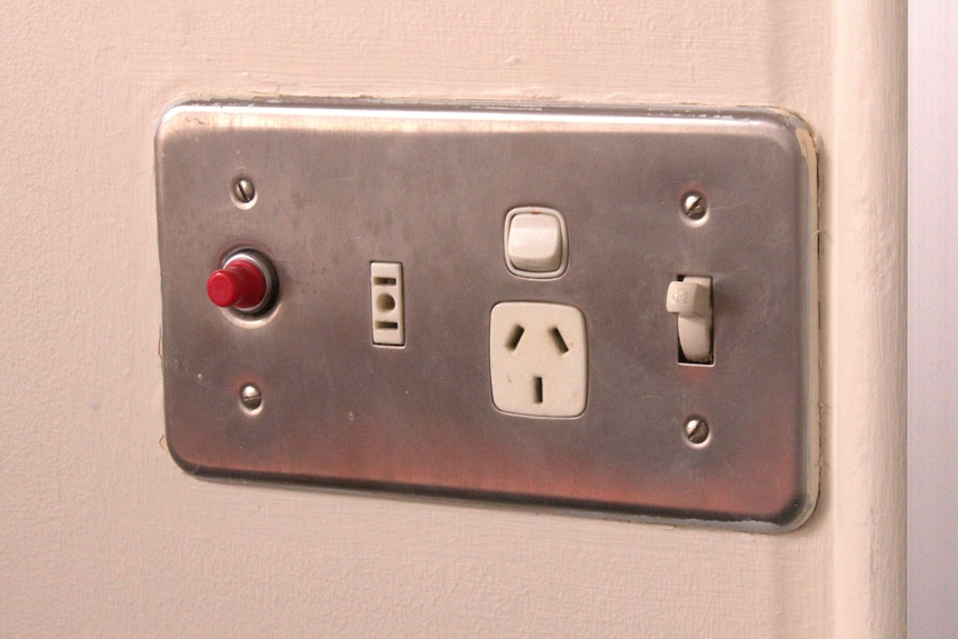 A powerpoint in the wall with a small red button on the left hand side.