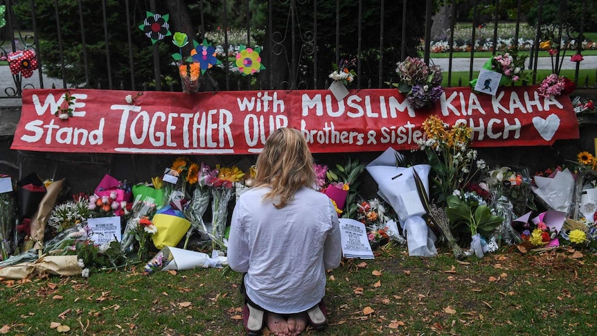 Members of the public mourn and lay floral tributes at a memorial wall in the Christchurch Botanical Gardens near the scene of mass killings, 49 worshipers attending the Masjid al-Noor Mosque.