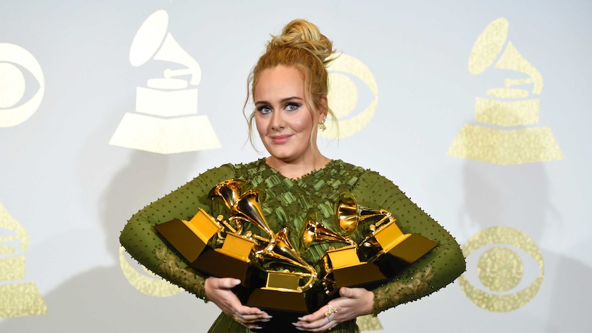 Adele poses in the Grammys press room with her five awards.