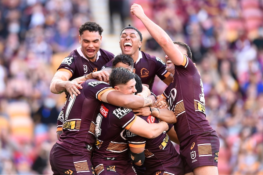 A bunch of Brisbane Broncos players congregate in a big group hug