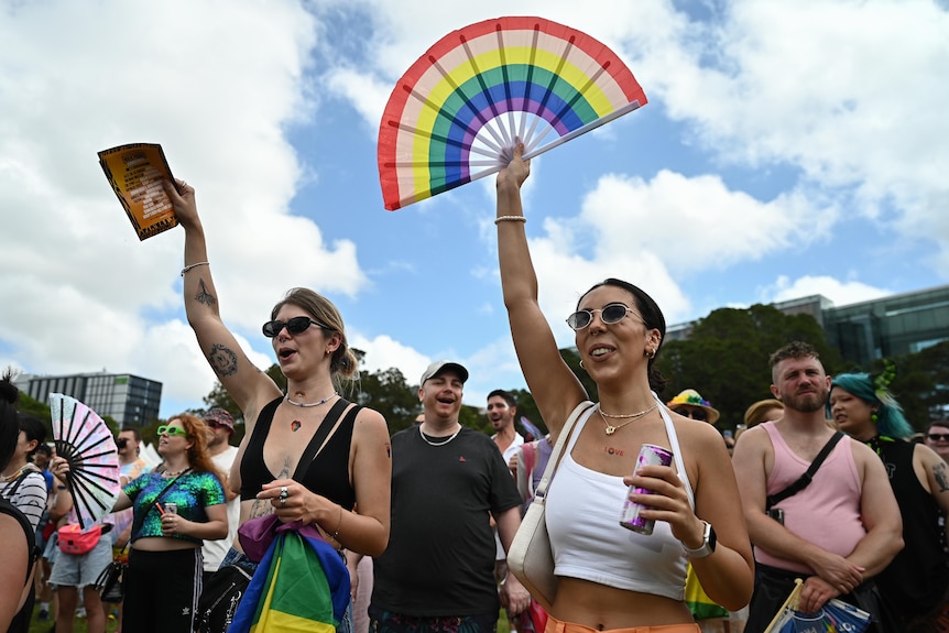 two women with their arms up at a festival